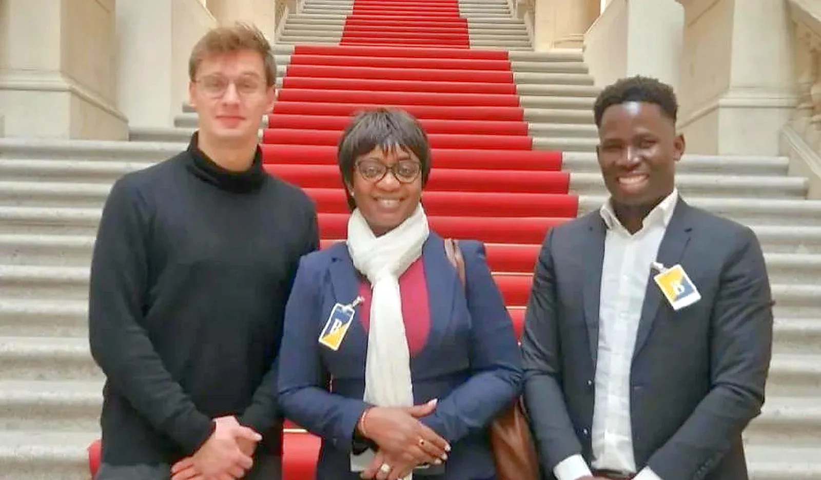 Trois représentants de l'APC réunis devant le grand escalier d'une institution publique