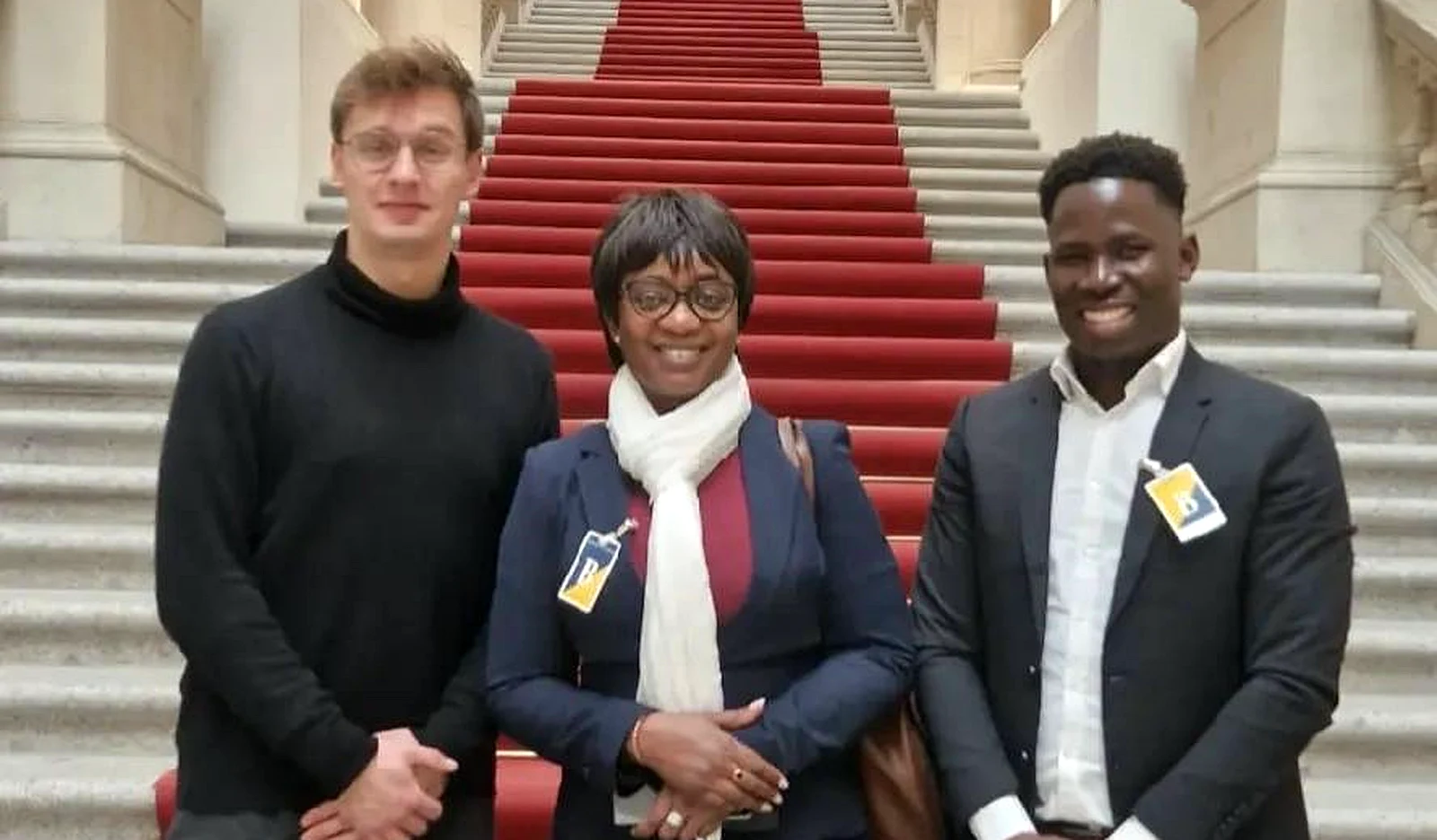 Trois représentants de l'APC réunis devant le grand escalier d'une institution publique